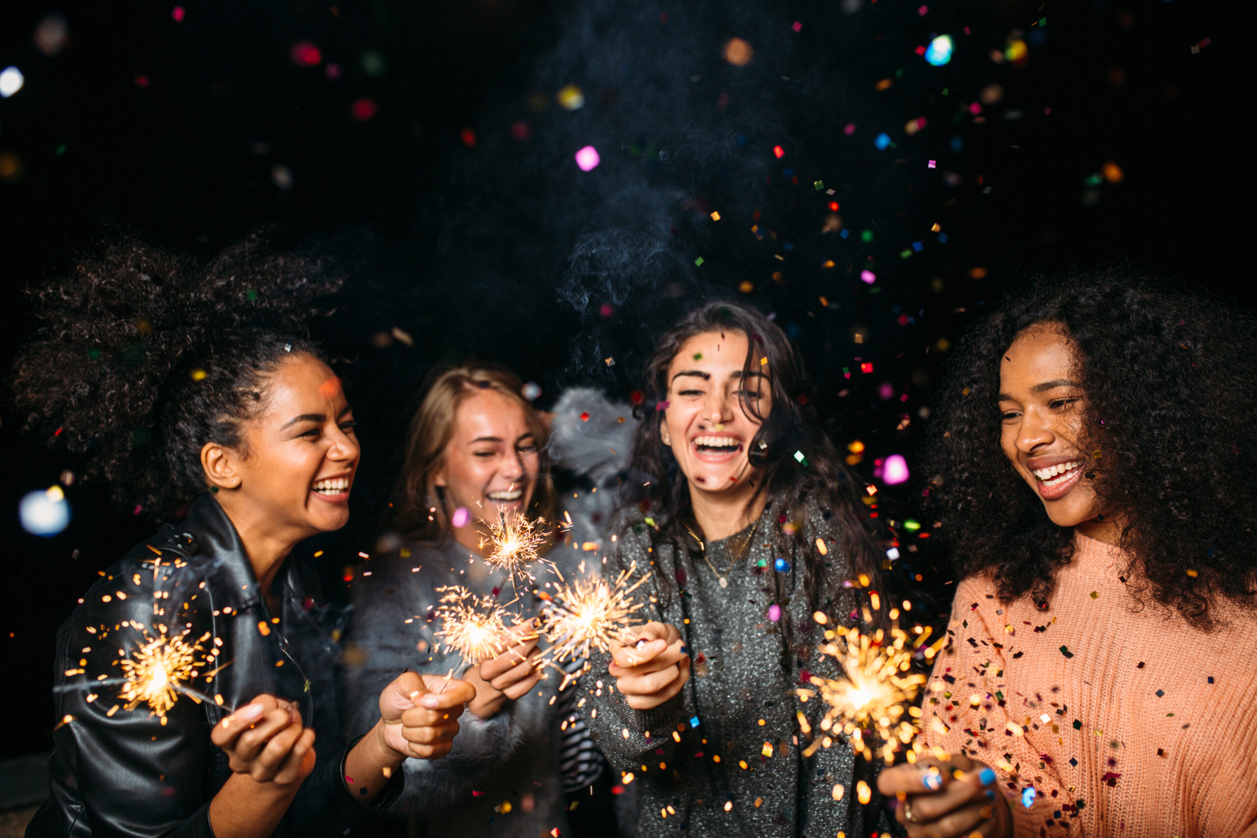 Happy,Women,At,Night.,Laughing,Friends,With,Sparklers,Under,Confetti.